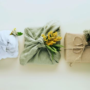 three Christmas gifts simply wrapped in linen and tied with twine